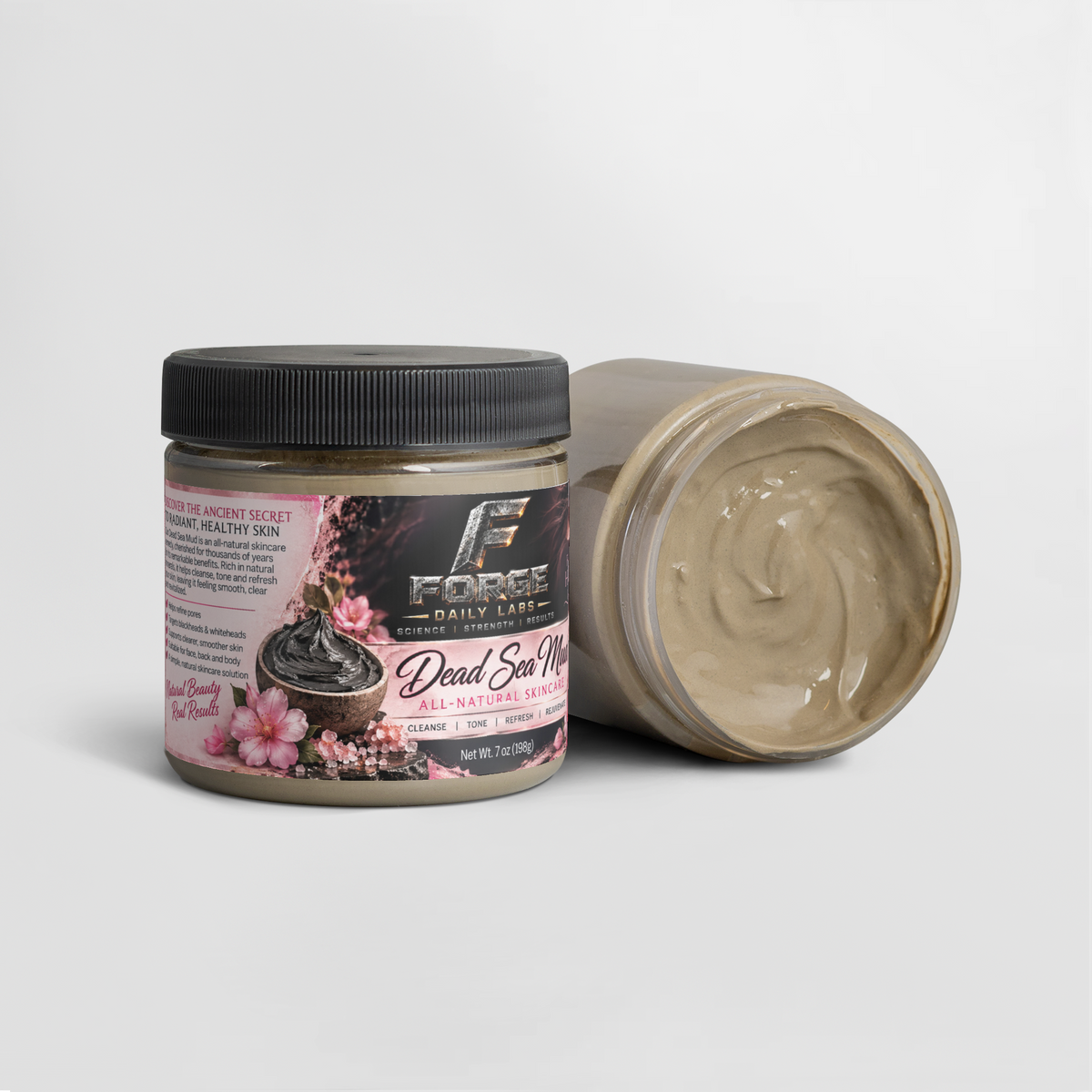 A jar of Dead Sea Mud body scrub by Force Daily Labs, with one closed jar showing the black lid and label, and one open jar showing the thick beige scrub inside, on a light gray background.
