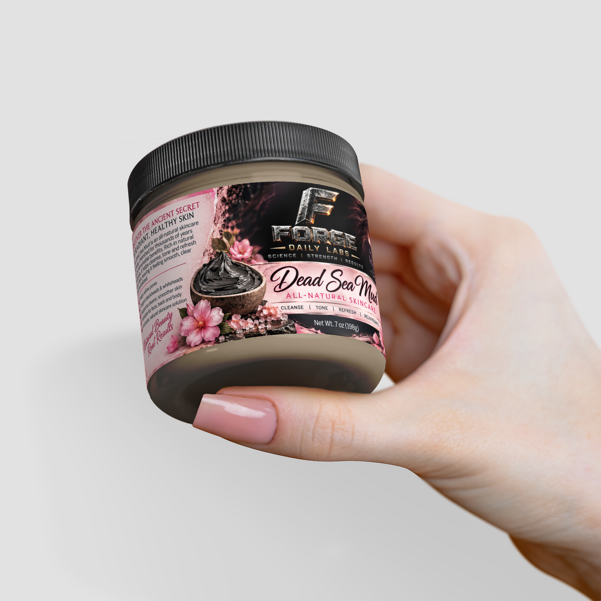 A hand with pink manicured nails holds a jar of Edge Daily Skincare Dead Sea Mud against a light gray background.