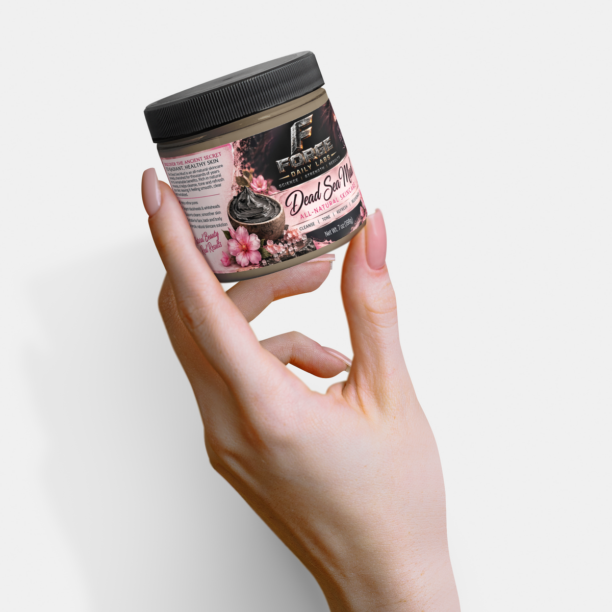 A hand holding a jar of Force Makeup Dead Skin Mud against a clean white background.